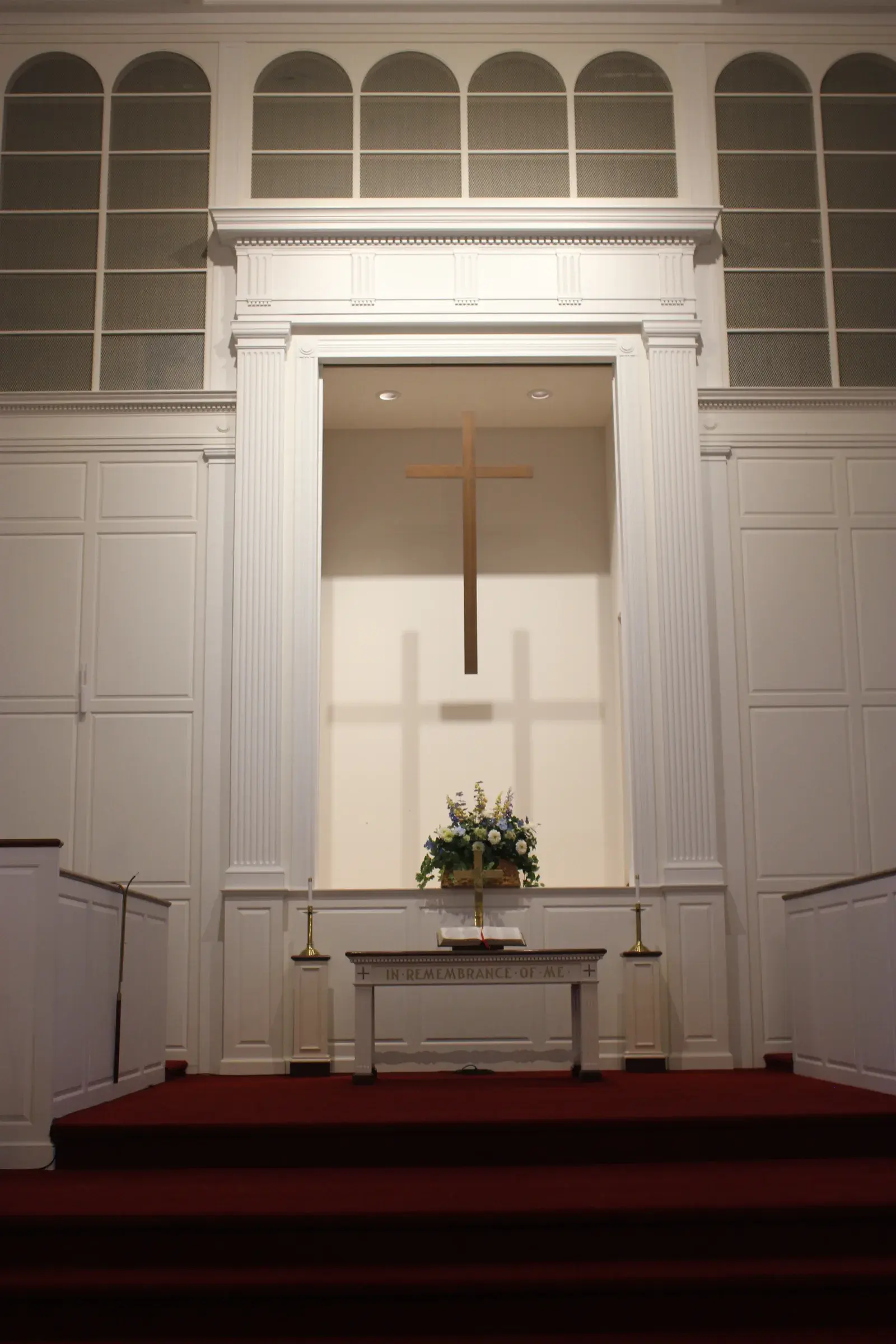 The chancel of Second Baptist Church of Suffield, with its cross and arched organ screens above the communion table